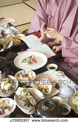 Stock Photo - Two young women eating dinner in Japanese style inn. Fotosearch