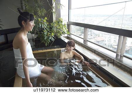 Two young women talking in hot springs View Large Photo Image Stock Image - Two young women talking in hot springs. Fotosearch
