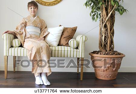 A 若い女性 中に 着物 ソファーの上に座る ピクチャー U Fotosearch