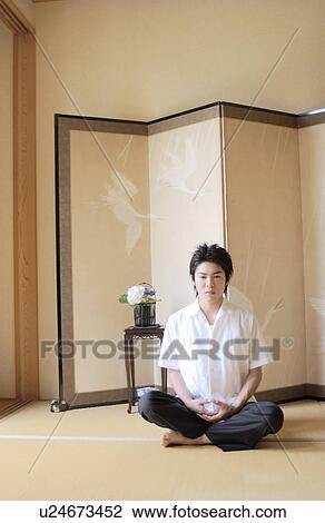 Stock Image - A man sitting in lotus position. Fotosearch