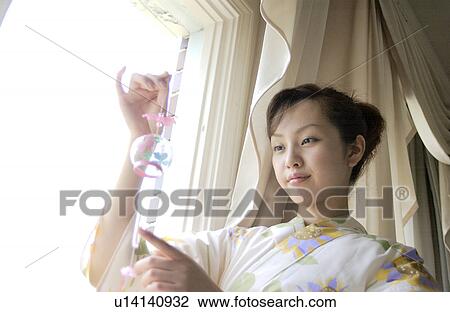 A woman holding wind chime View Large Photo Image Stock Image - A woman holding wind chime. Fotosearch