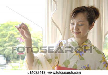 A woman holding wind chime View Large Photo Image Stock Photo - A woman holding wind chime. Fotosearch