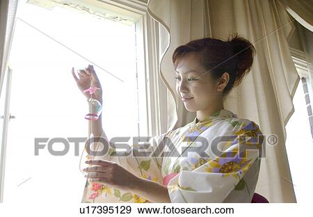 Stock Photo - A woman holding wind chime. Fotosearch