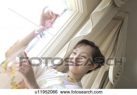 Stock Photograph - A woman holding wind chime. Fotosearch