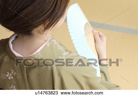 A woman in kimono holding fan View Large Photo Image Stock Image - A woman in kimono holding fan. Fotosearch