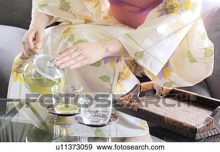 Stock Photo - A woman serving green tea. Fotosearch