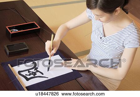 Stock Photograph - A woman writing letters with ink brush. Fotosearch