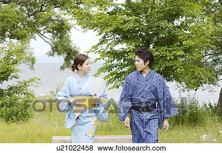 Stock Photo - A young couple in kimono walking. Fotosearch