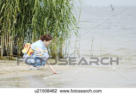 A young woman in kimono touching water View Large Photo Image Stock Image - A young woman in kimono touching water. Fotosearch