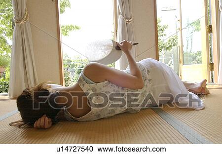 Stock Image - A young woman lying in tatami room. Fotosearch