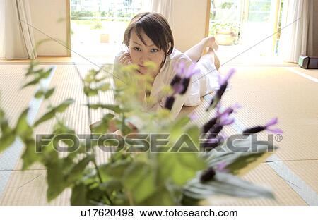 A young woman lying on tatami mat View Large Photo Image Stock Photo - A young woman lying on tatami mat. Fotosearch