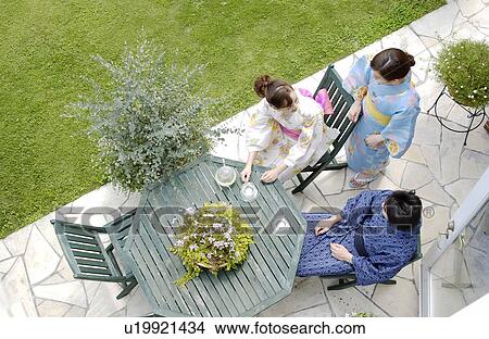 Three people in kimono sitting at outdoor table View Large Photo Image Picture - Three people in kimono sitting at outdoor table. Fotosearch