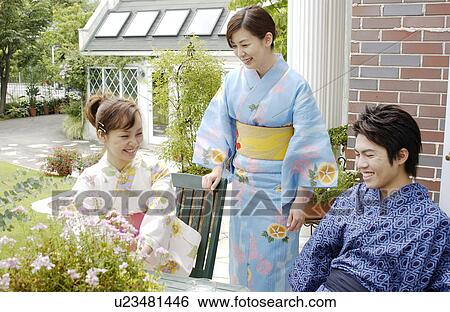 Stock Photograph - Three people in kimono talking in garden. Fotosearch