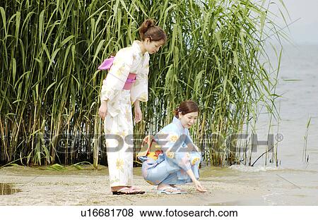 Stock Photo - Two women in kimono talking on lake side. Fotosearch