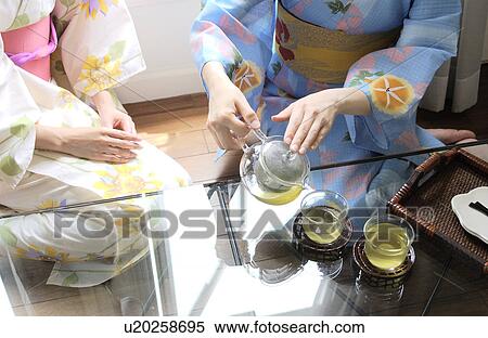 Stock Photography - Two women serving green tea. Fotosearch