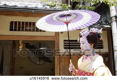 Stock Photograph - A Geisha woman holding umbrella. Fotosearch
