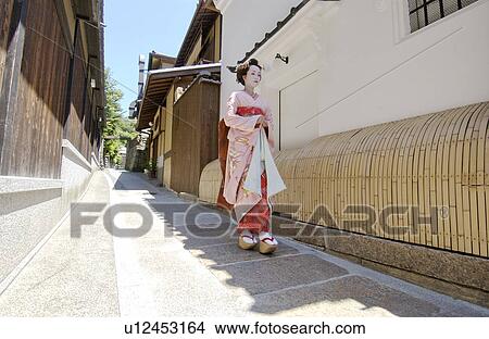 A Geisha woman walking on a street View Large Photo Image Picture - A Geisha woman walking on a street. Fotosearch