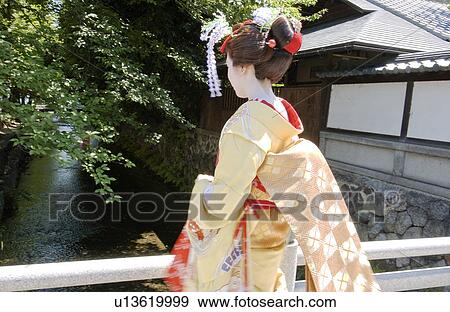 Rear view of a Geisha woman standing by a river View Large Photo Image Stock Photo - Rear view of a Geisha woman standing by a river. Fotosearch