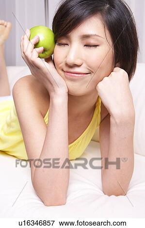 Portrait of Natural Young girl holding Apple, Smiling View Large Photo Image Stock Photo - Portrait of Natural Young girl holding Apple, Smiling. Fotosearch