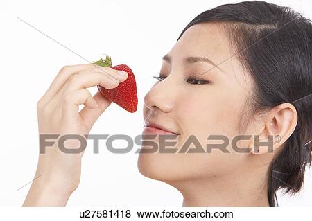 Portrait of Natural Young girl smelling strawberry View Large Photo Image Stock Photo - Portrait of Natural Young girl smelling strawberry. Fotosearch