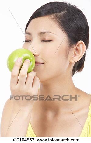 Stock Photo - Portrait of Natural Young girl smelling Apple. Fotosearch