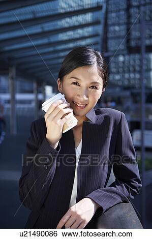 Stock Photograph - Young Businesswoman Holding Coffee Cup, Smiling. Fotosearch