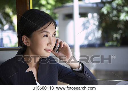Young Businesswoman Riding Tram and using mobile phone, Smiling View Large Photo Image Stock Image - Young Businesswoman Riding Tram and using mobile phone, Smiling. Fotosearch