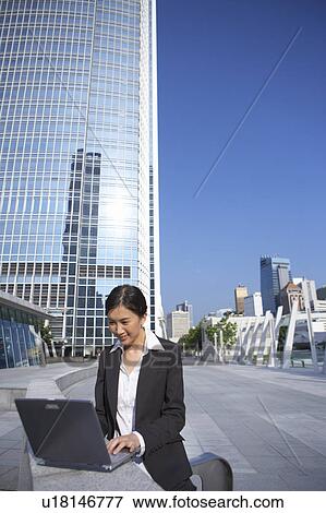 Young Businesswoman using Laptop Outdoor View Large Photo Image Stock Photo - Young Businesswoman using Laptop Outdoor. Fotosearch