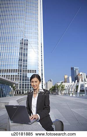Stock Photography - Young Businesswoman using Laptop Outdoor. Fotosearch