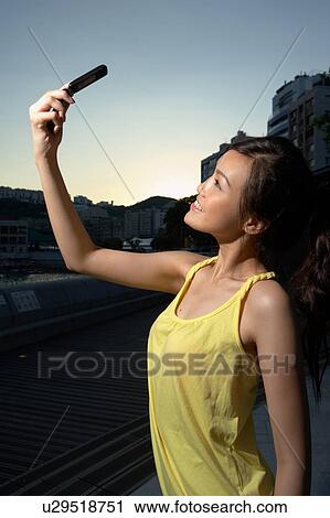 Stock Image - Young Lady Holding Mobile Phone. Fotosearch