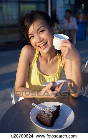 Young Lady Sitting Outdoor Cafe, Holding Cup, Smiling View Large Photo Image Picture - Young Lady Sitting Outdoor Cafe, Holding Cup, Smiling. Fotosearch