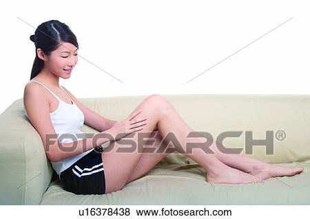 Stock Photo - Young woman sitting on sofa. Fotosearch