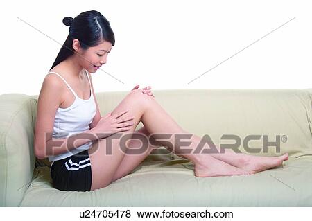 Stock Photo - Young woman sitting on sofa. Fotosearch