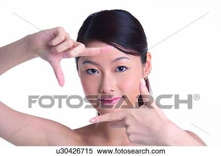 Stock Photography - Young girl with hands in front of face, smiling. Fotosearch