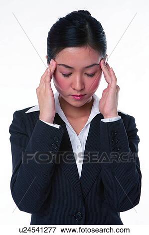 Stock Photo - Young woman in business suit, eyes closed, pressing head. Fotosearch