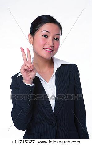 Young woman in business suit, raising two fingers View Large Photo Image Stock Photo - Young woman in business suit, raising two fingers. Fotosearch