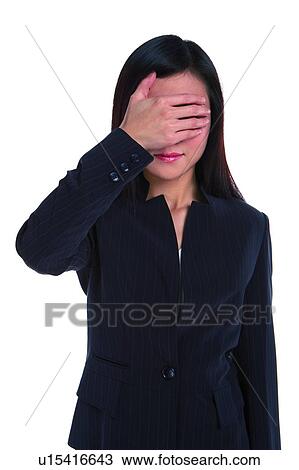 Stock Image - Young woman in business suit with hand covering eyes. Fotosearch