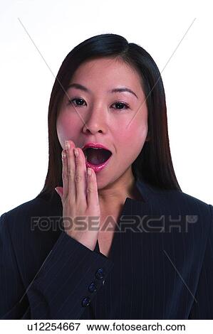 Stock Photo - Young woman in business suit, yawning. Fotosearch