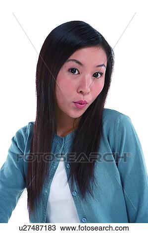 Stock Image - Young woman looking at camera and whistling. Fotosearch