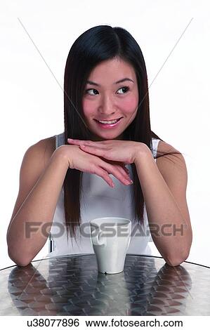 Young woman sitting with hands supporting chin View Large Photo Image Stock Photograph - Young woman sitting with hands supporting chin. Fotosearch