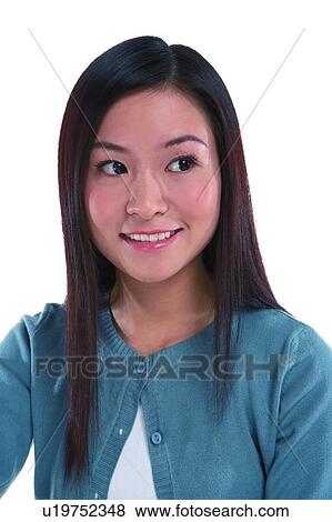 Stock Photo - Young woman smiling, looking away, close-up. Fotosearch