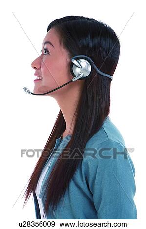 Stock Photo - Young woman wearing headphone and smiling in side view. Fotosearch