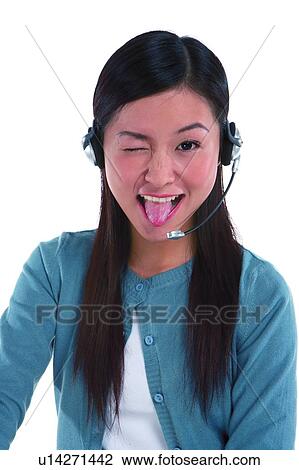Young woman wearing headphone, closing one eye and making a face View Large Photo Image Stock Image - Young woman wearing headphone, closing one eye and making a face. Fotosearch