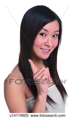 Young woman with long hair, smiling, raising index finger View Large Photo Image Stock Image - Young woman with long hair, smiling, raising index finger. Fotosearch