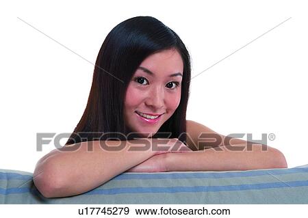 Young woman with long hair, smiling, leaning on sofa, close-up View Large Photo Image Stock Photo - Young woman with long hair, smiling, leaning on sofa, close-up. Fotosearch