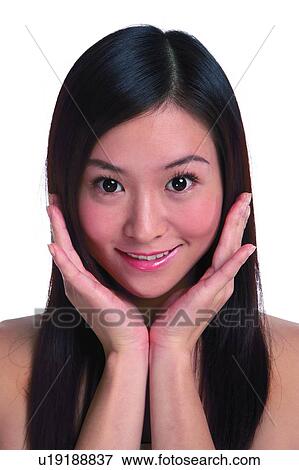 Stock Photo - Young woman with long hair, smiling, hands cupped. Fotosearch