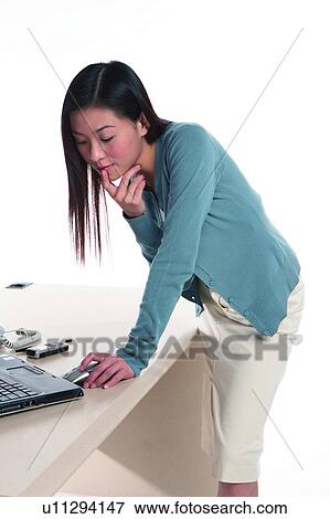 Young woman bending over with hand on mouse View Large Photo Image Stock Photo - Young woman bending over with hand on mouse. Fotosearch