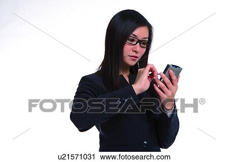 Young woman in business suit, wearing glasses, using palmtop View Large Photo Image Stock Image - Young woman in business suit, wearing glasses, using palmtop. Fotosearch