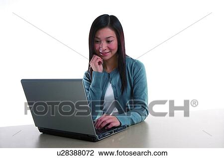 Young woman sitting and looking at laptop View Large Photo Image Stock Image - Young woman sitting and looking at laptop. Fotosearch