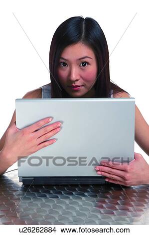 Young woman sitting behind the laptop View Large Photo Image Picture - Young woman sitting behind the laptop. Fotosearch